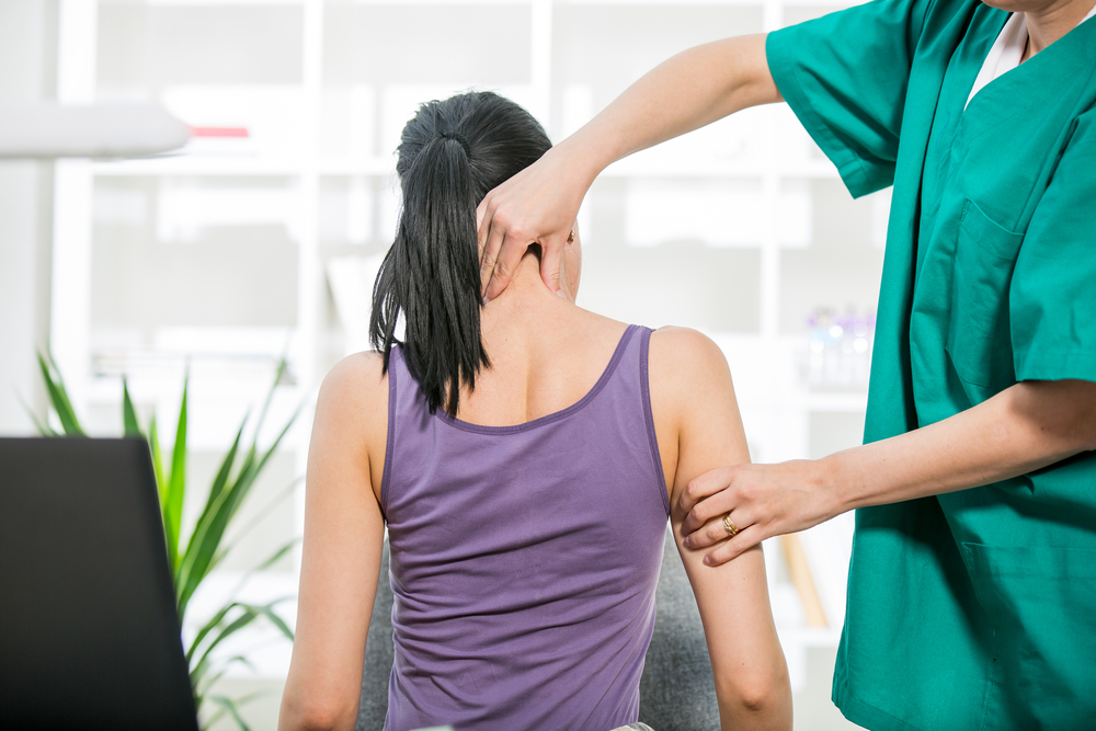 A chiropractor adjusts a patient's neck during a therapy session - Chiropractor Irving TX A chiropractor adjusts a patient's neck during a therapy session - Chiropractor Irving TX