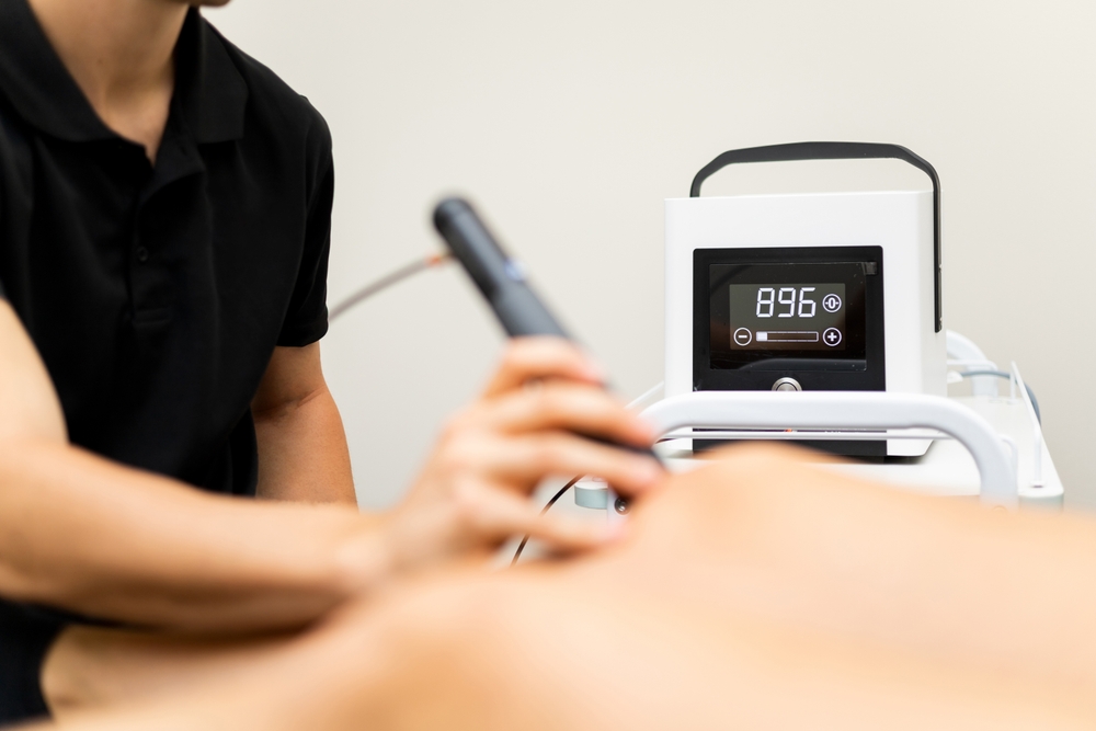 A chiropractor uses a laser therapy device during a treatment session - Chiropractor Irving TX A chiropractor uses a laser therapy device during a treatment session - Chiropractor Irving TX